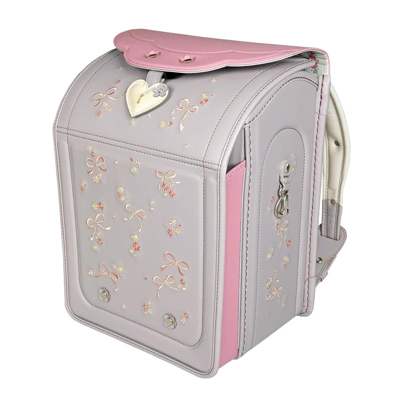 ララちゃんランドセル「トップん」グレー×ピンク。カブセに小花の飾りが散り、錠前の上にハート型のチャームが下がる
