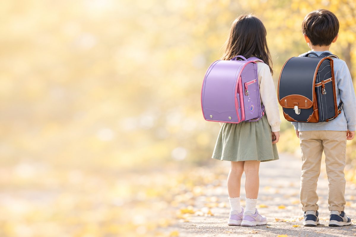 セイバンのファンタジーを背負った女の子と、セイバンのオロビアンコを背負った男の子の後ろ姿