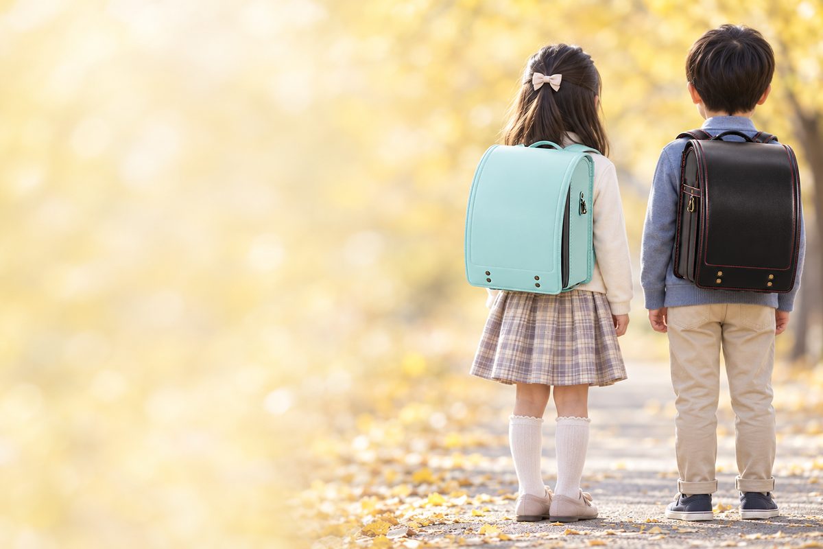 萬勇鞄のグリを背負った女の子と、萬勇鞄のゼストを背負った男の子の後ろ姿