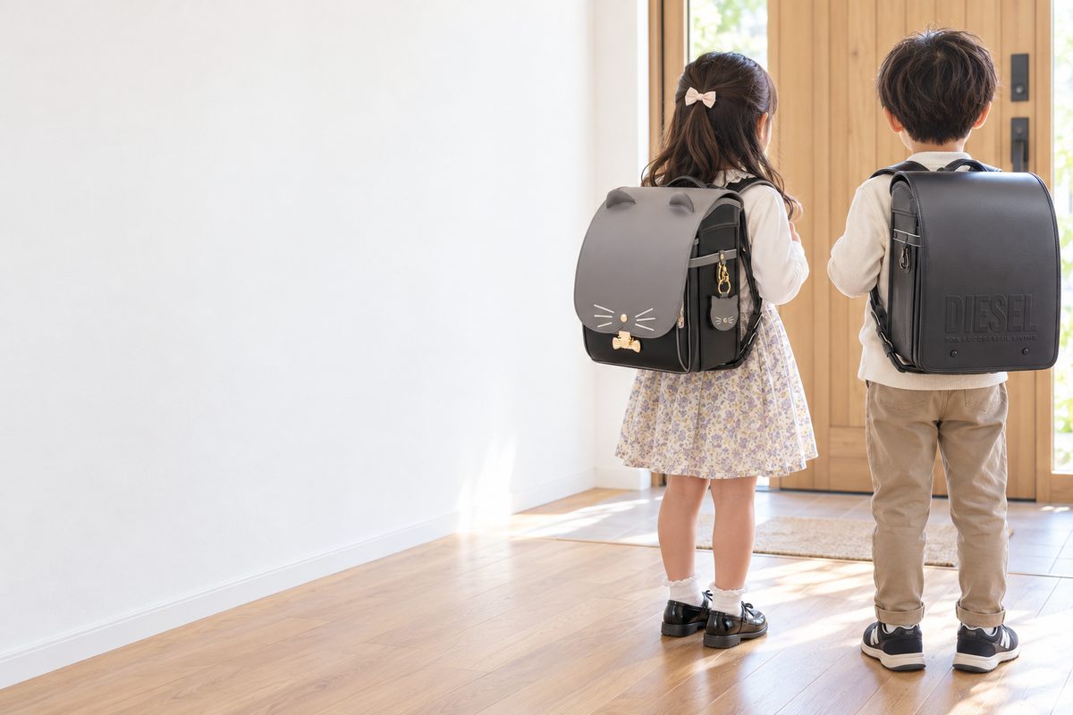 SHIFFONのポール＆ジョー クリザンテームチャトン（グレー）を背負った女の子と、DIESEL グロッシー＆マット（ガンメタル）を背負った男の子の後ろ姿